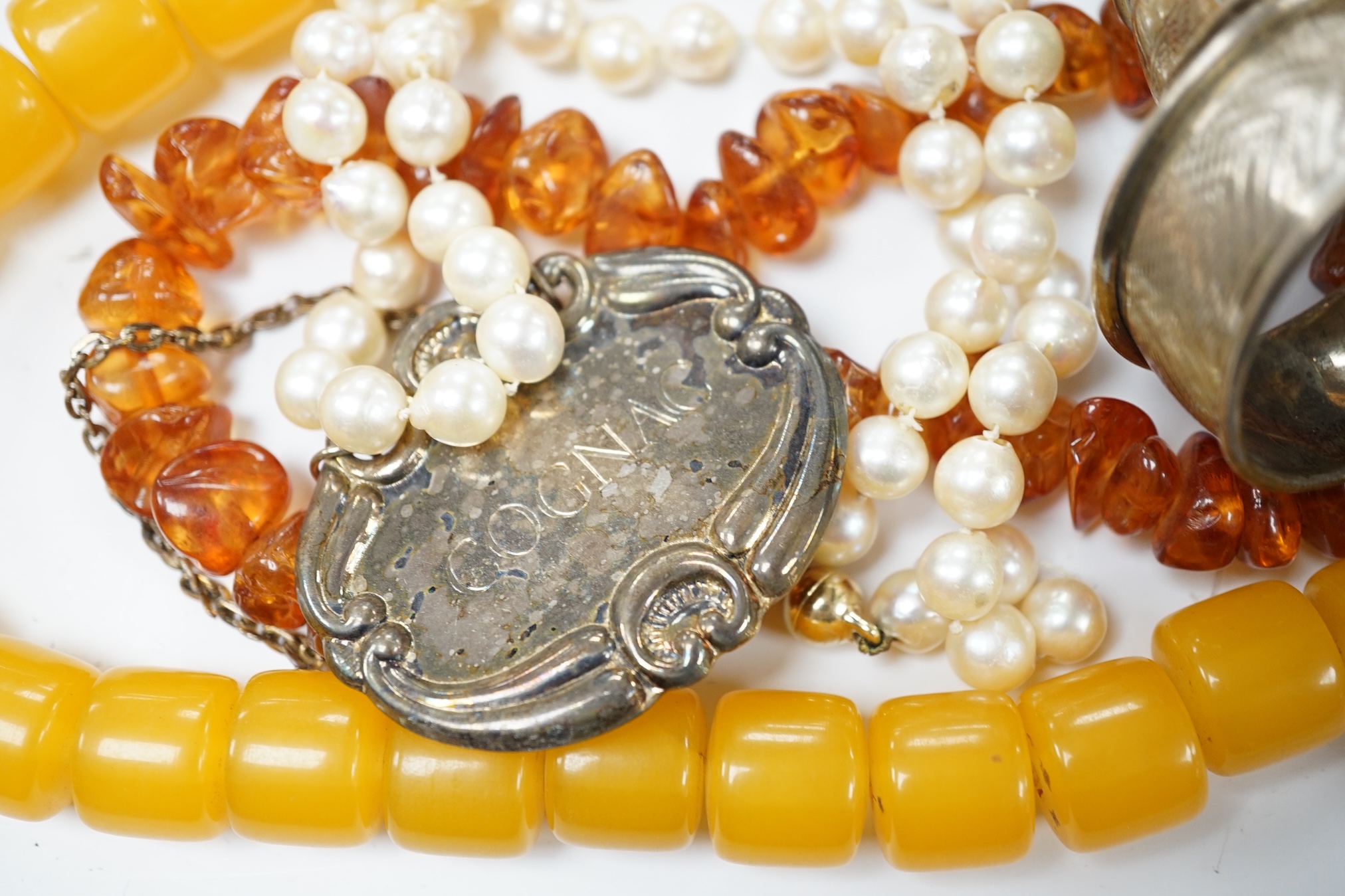 Nine assorted silver napkin rings, four modern silver wine labels, a plated wine label, a white metal ashtray, a cultured pearl necklace and a large quantity of assorted costume jewellery. Condition - fair